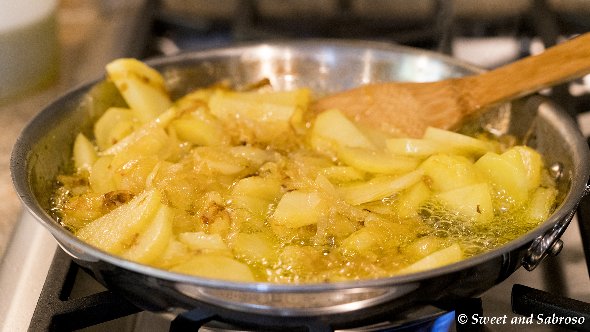 Potatoes and Onions Frying in Olive Oil To Make A Tortilla Española (Spanish Omelet) 