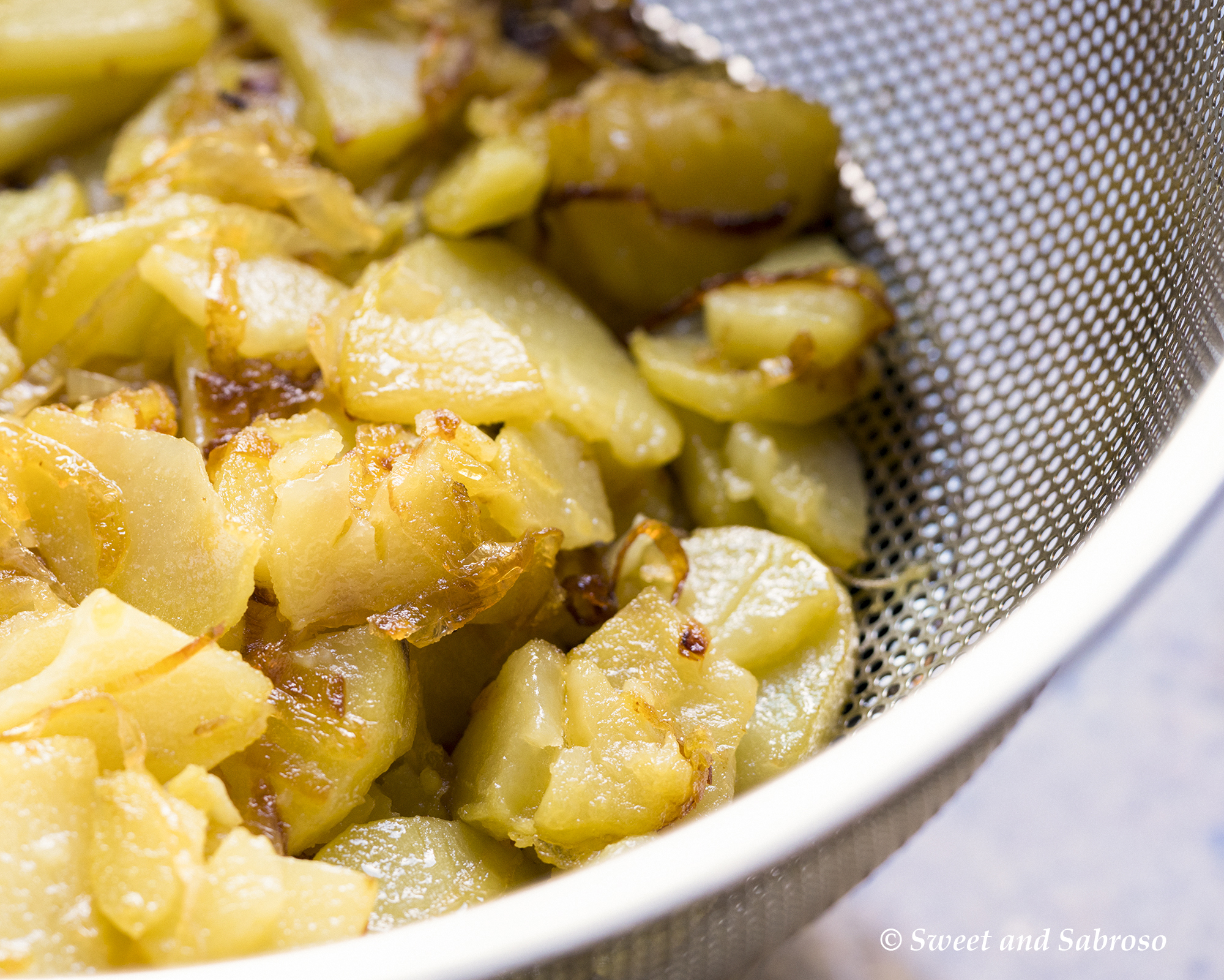 Tortilla Española (Spanish Omelet) Fried Potatoes and Onions Draining in Colander