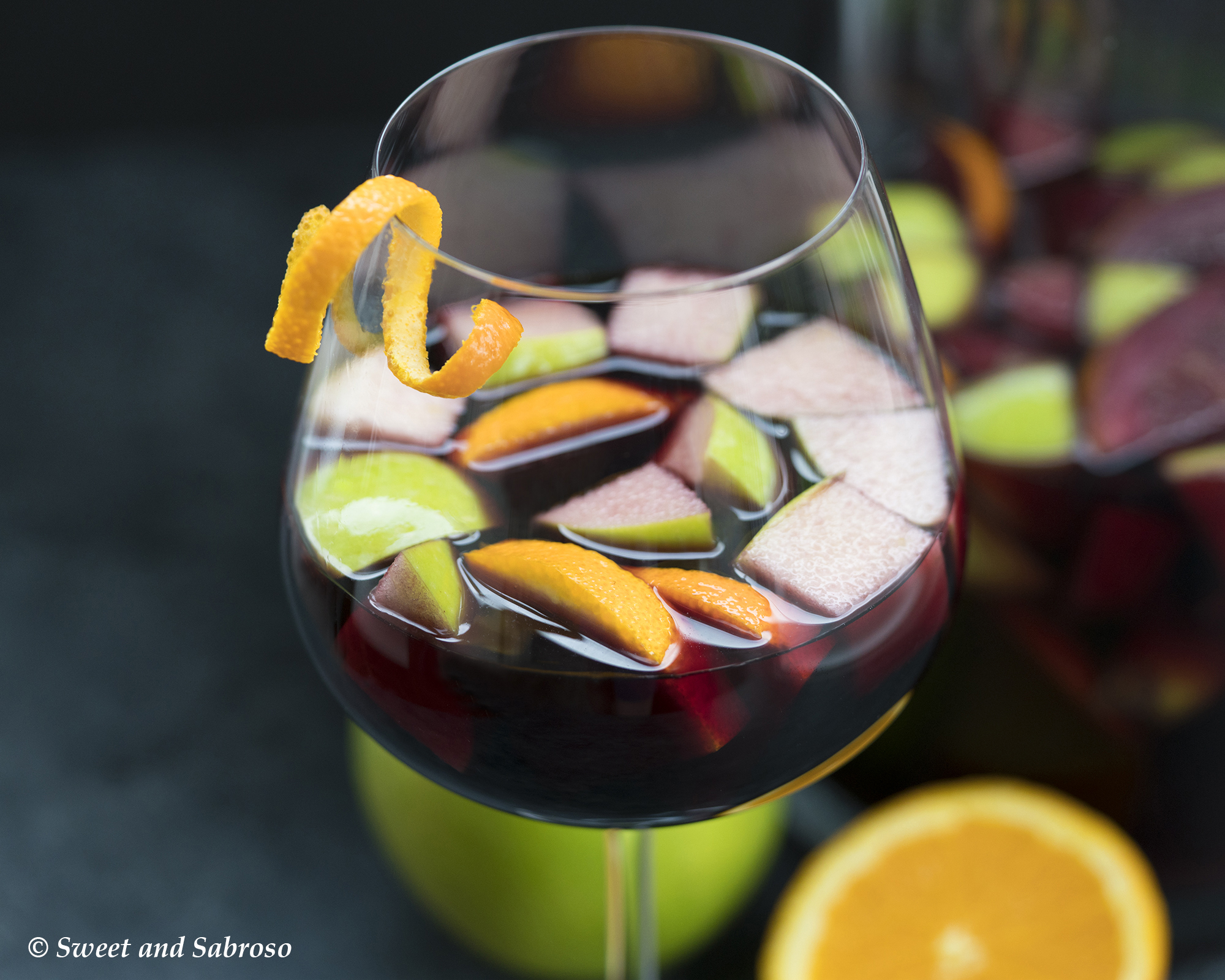 Glass of Classic Spanish Red Wine Sangria with Fresh Green Apples and Orange Slices