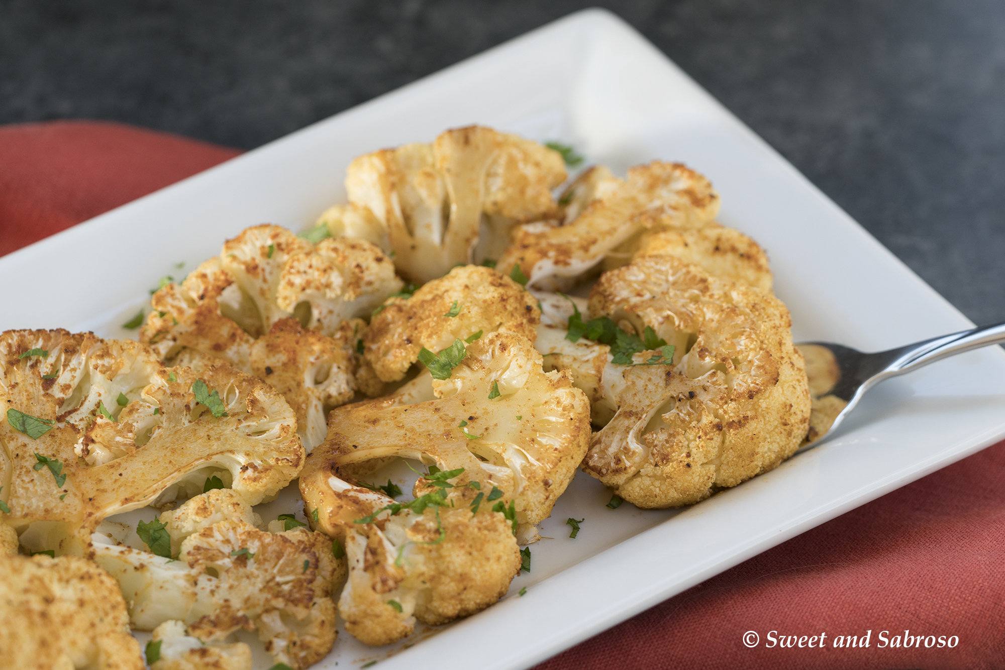 Roasted Cauliflower with Olive Oil, Cumin and Paprika Plated on a White Platter